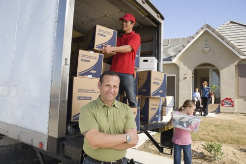 Professional movers handling boxes and furniture for a West Hendon home relocation